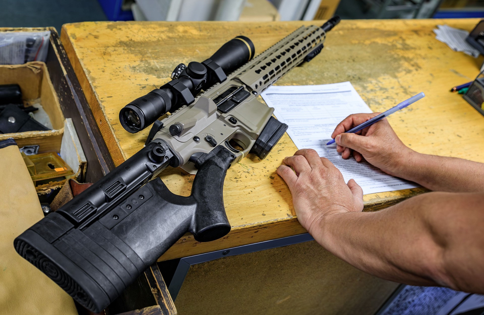 California gun shop: buyer signs paperwork for an AR-15 rifle, state regulations